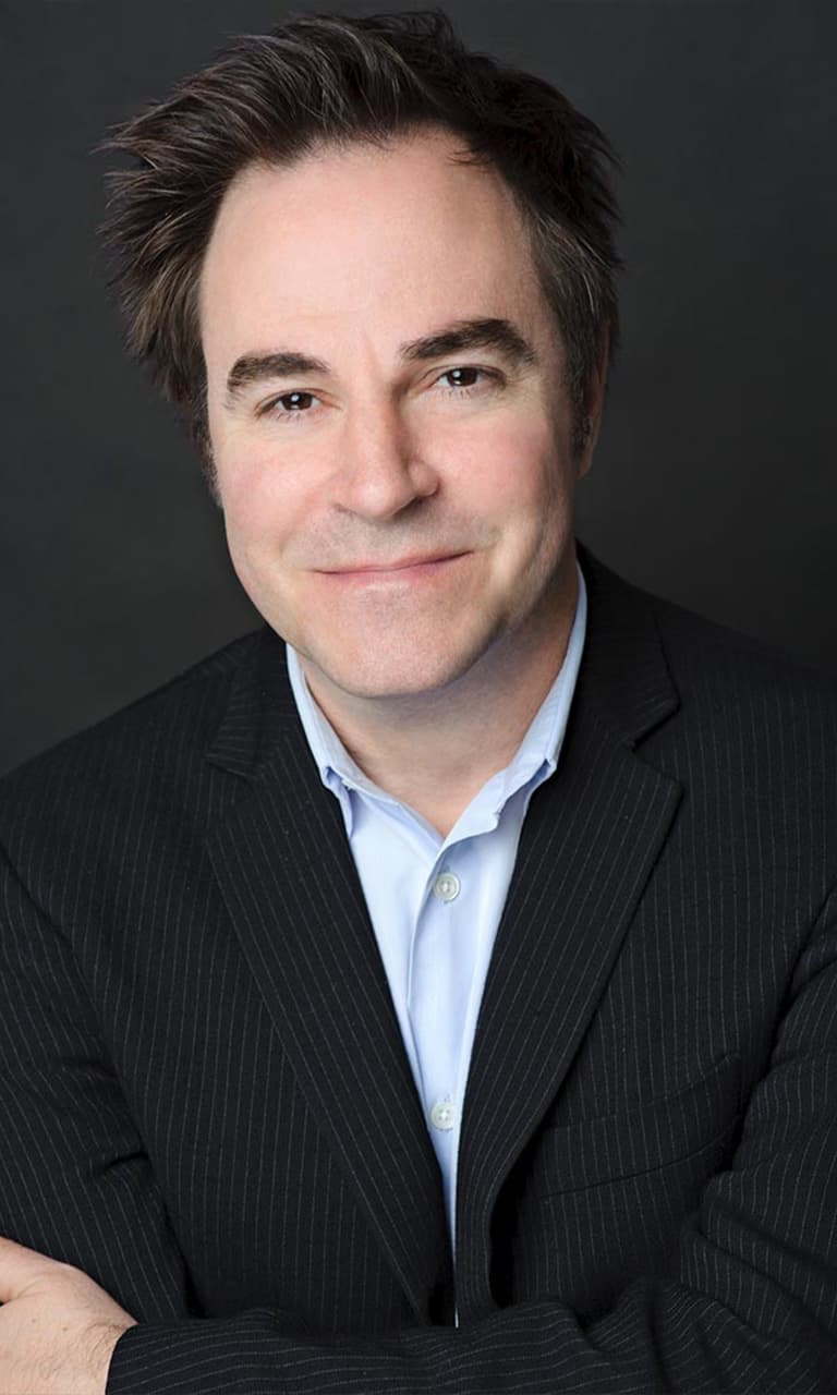 An original portrait photo, a smiling man in a dark suit jacket