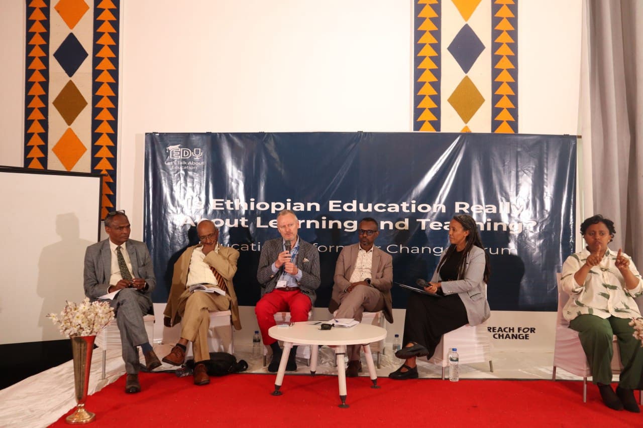 A panel of speakers on stage under the banner Is Ethiopian Education Really About Learning and Teaching?