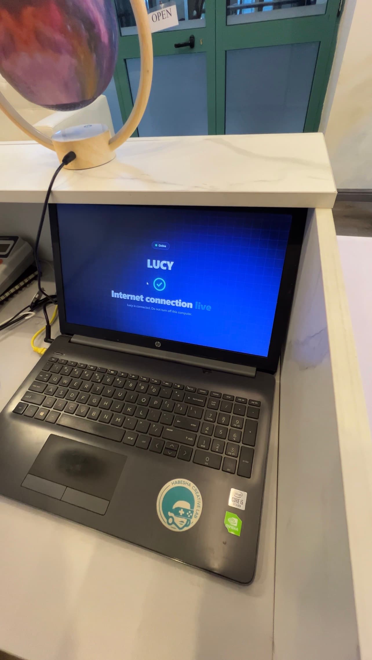 Laptop at the reception desk showing Lucy online with the internet connection live