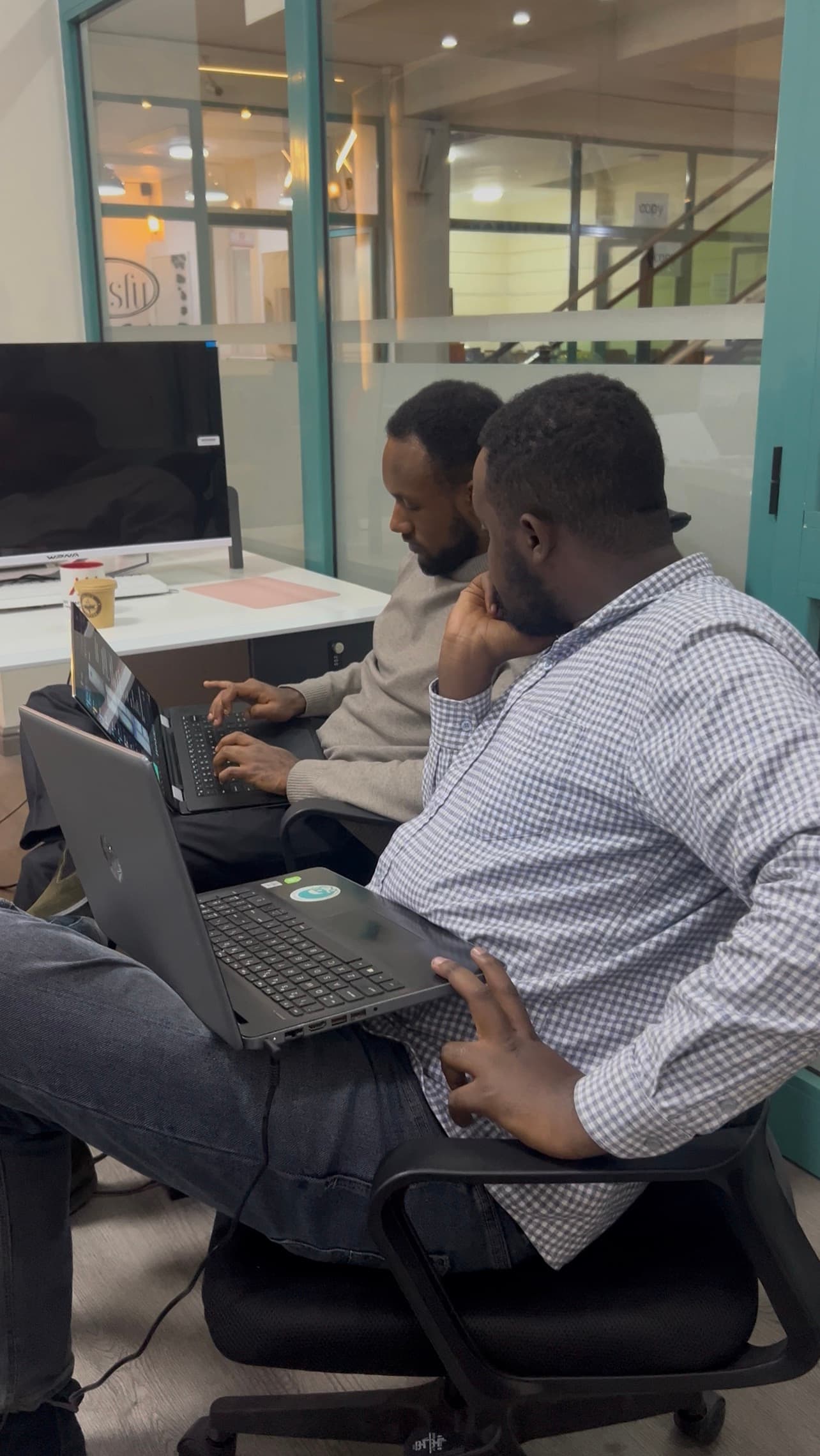 Two Lucy team members working through the system on their laptops